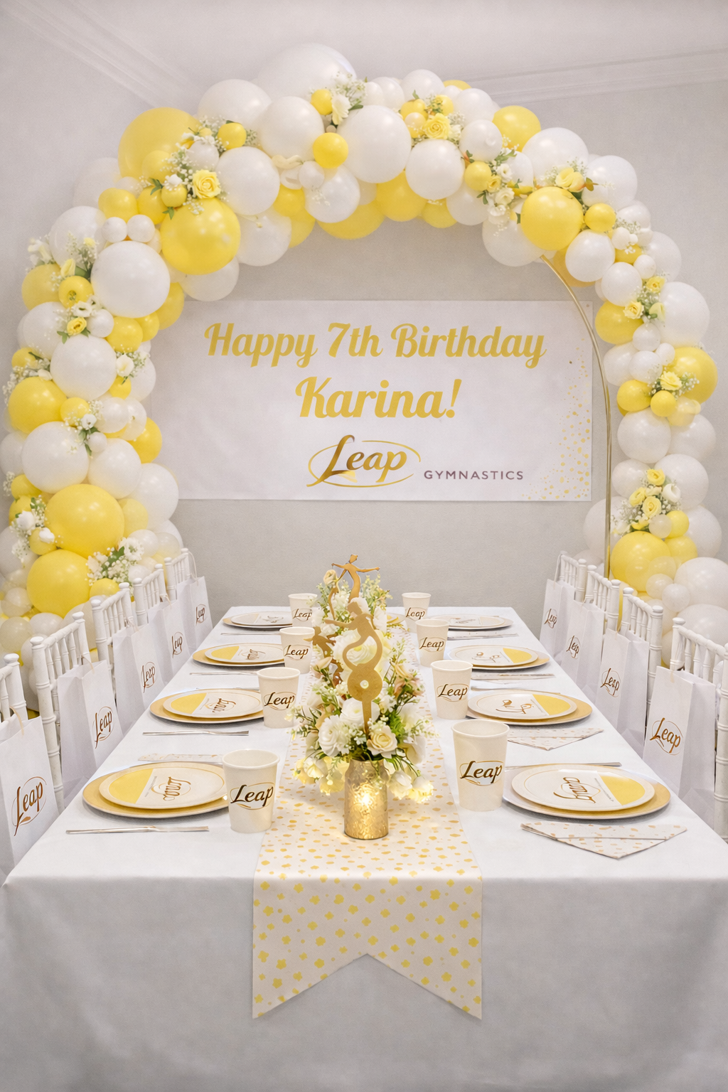 Leap Gymnastics Deluxe birthday party setup with rose gold and pink balloon garland, personalised banner, branded plates, cups, and centrepiece