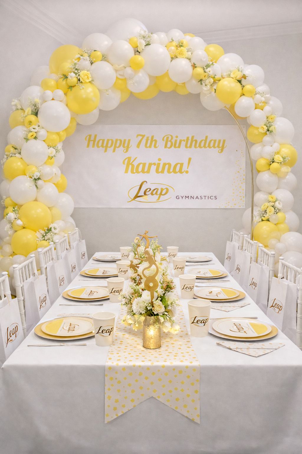 Leap Gymnastics Deluxe birthday party setup with rose gold and pink balloon garland, personalized banner, branded plates, cups, and centrepiece